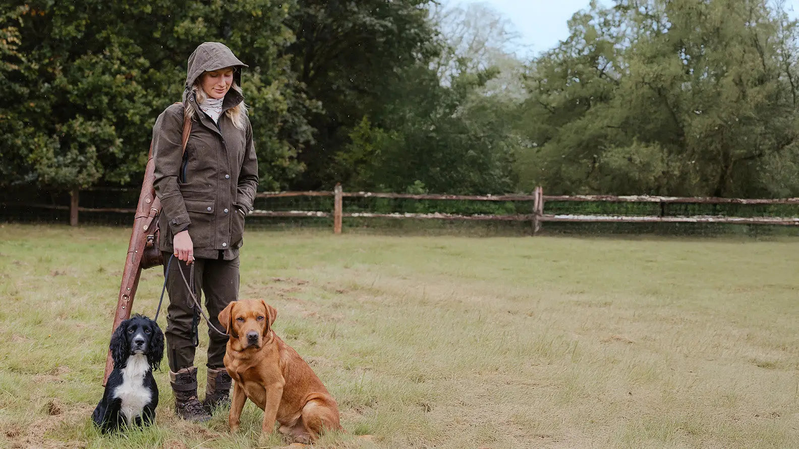 Woman in forest clothing with two dogs for Country Content UK SS25 photoshoot