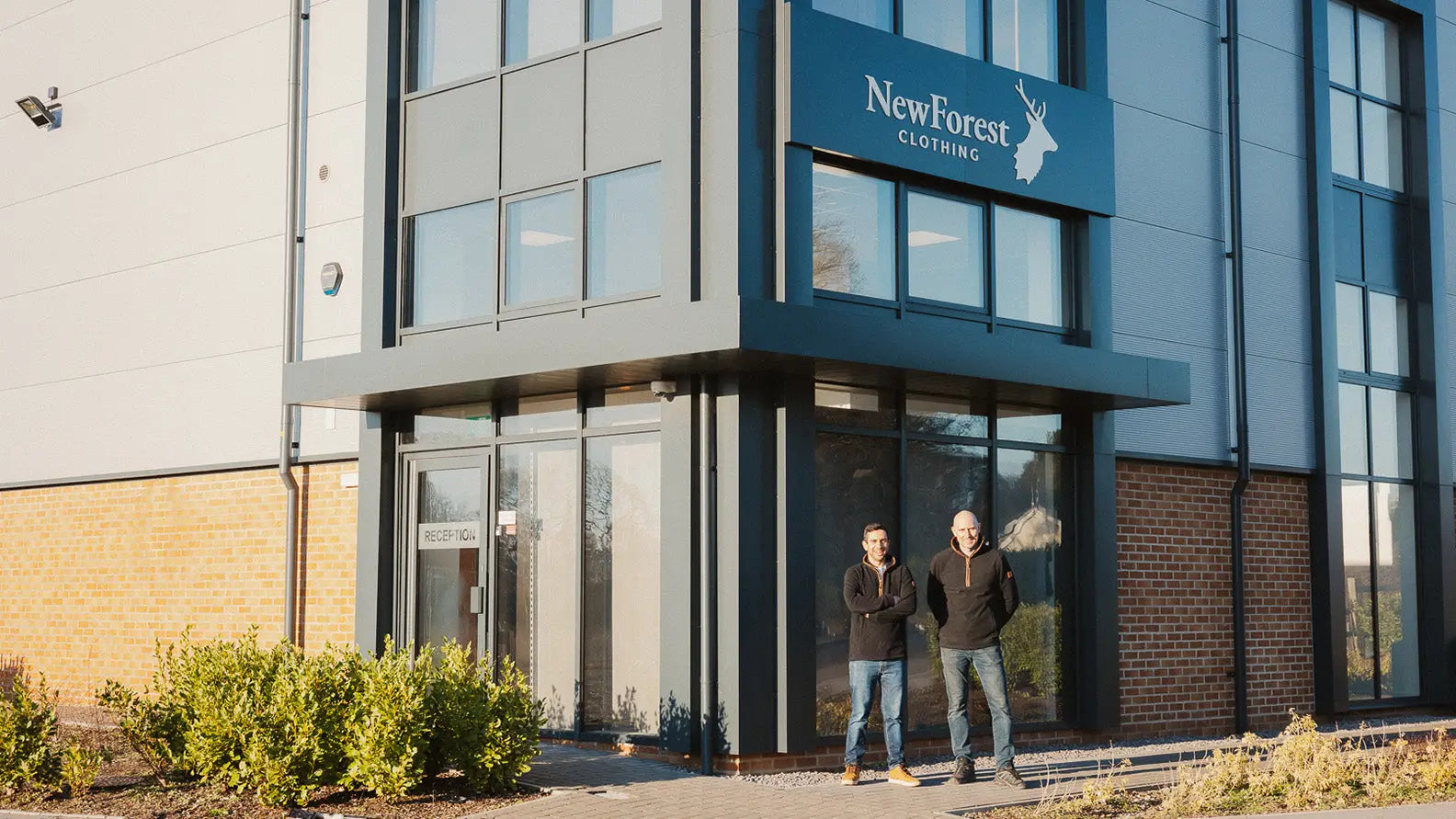 Modern commercial building with large windows and Forest Clothing sign showcasing quality outdoor gear