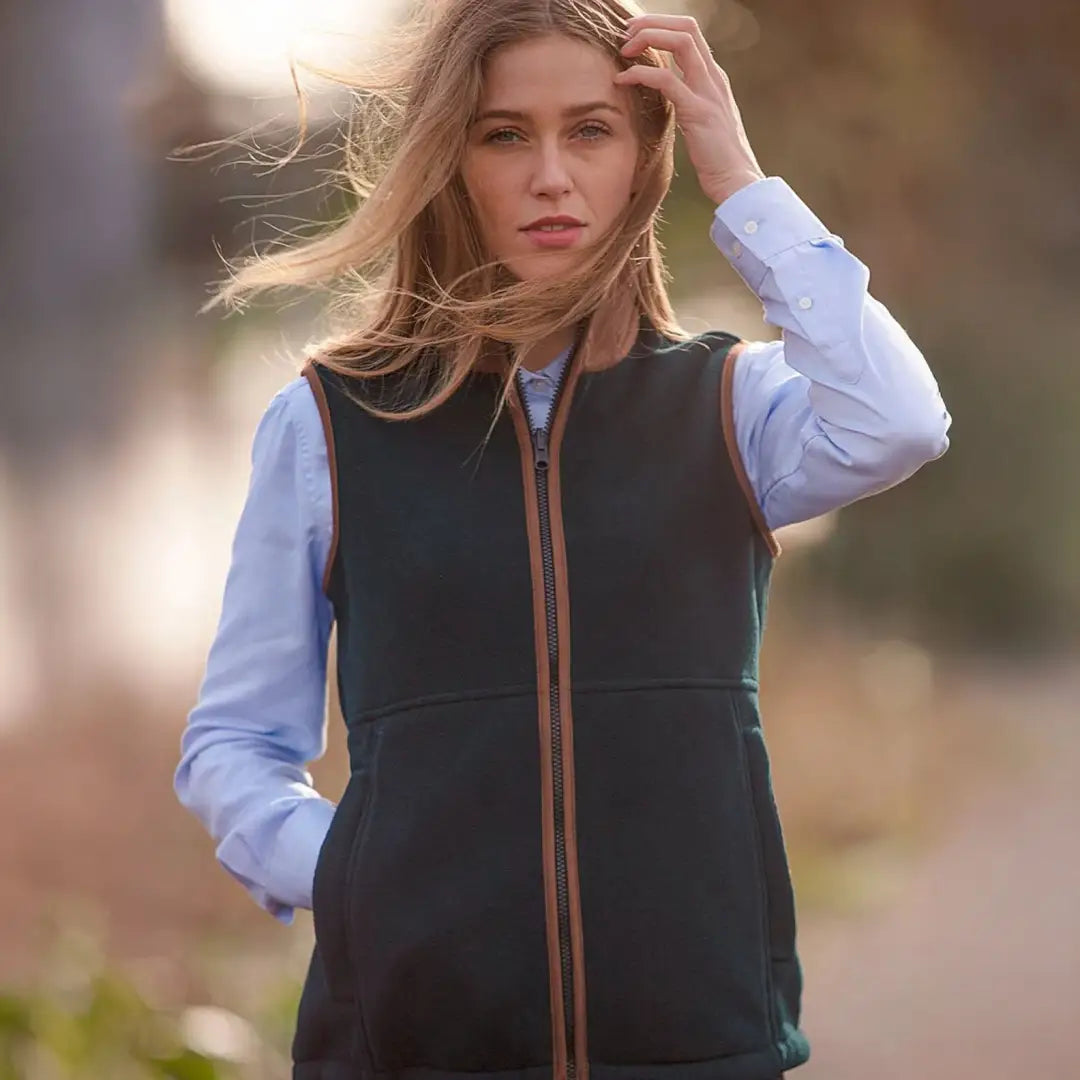 Woman’s dark green fleece vest with brown trim, perfect for warmer days worn as an extra layer underneath