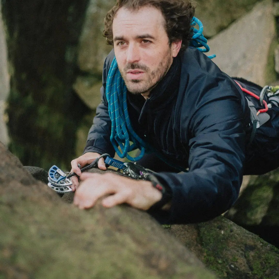 Man climbing with gear wearing Buffalo Belay Jacket, perfect for belay adventures