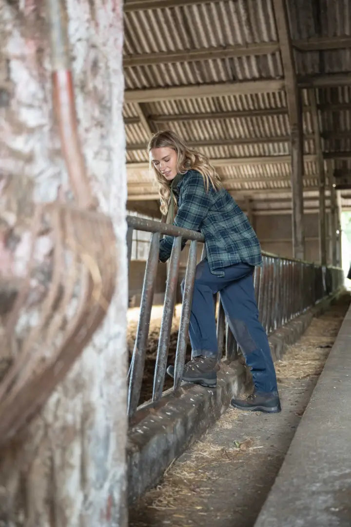 Blue plaid flannel shacket with microfleece lining, black gloves, jeans, and sturdy boots