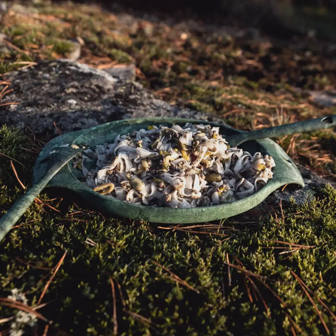 Green leaf-shaped Kupilka Plate filled with delicious food, perfect for outdoor adventures