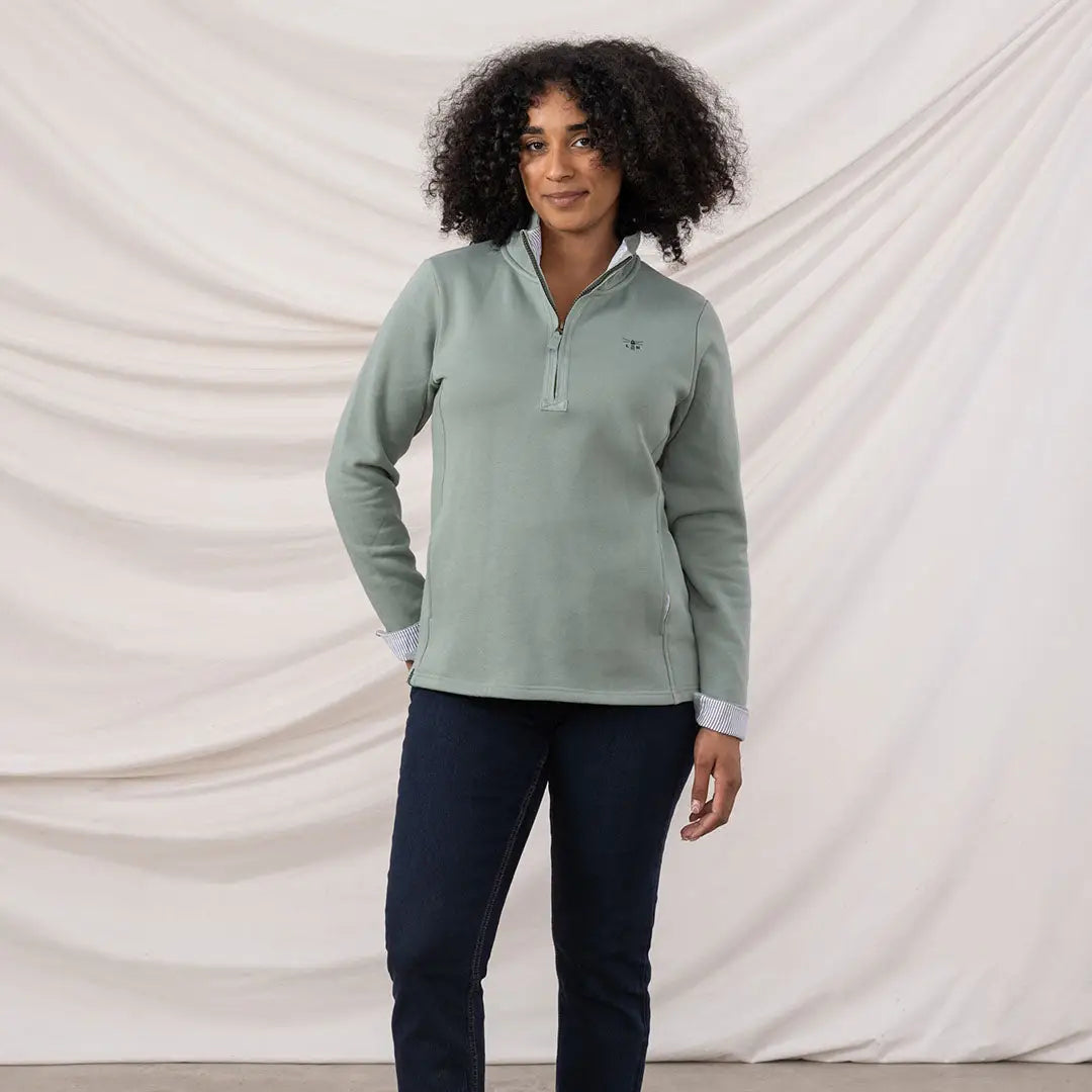 Lighthouse Ladies Shore II Jersey woman in sage green quarter-zip sweatshirt and dark blue trousers