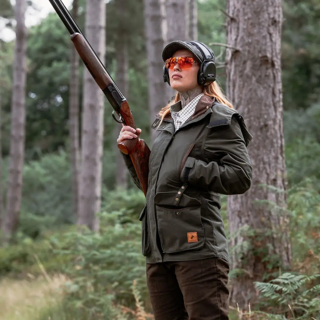 Woman in hunting attire with shotgun wearing Forest Ladies Marsh Jacket outdoors