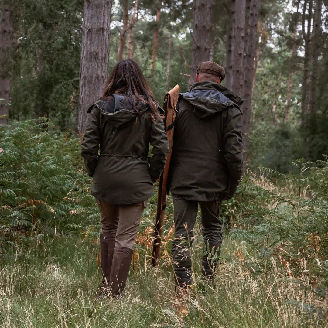 Two people in hunting attire walking in the forest wearing the New Forest Ladies Marsh Jacket
