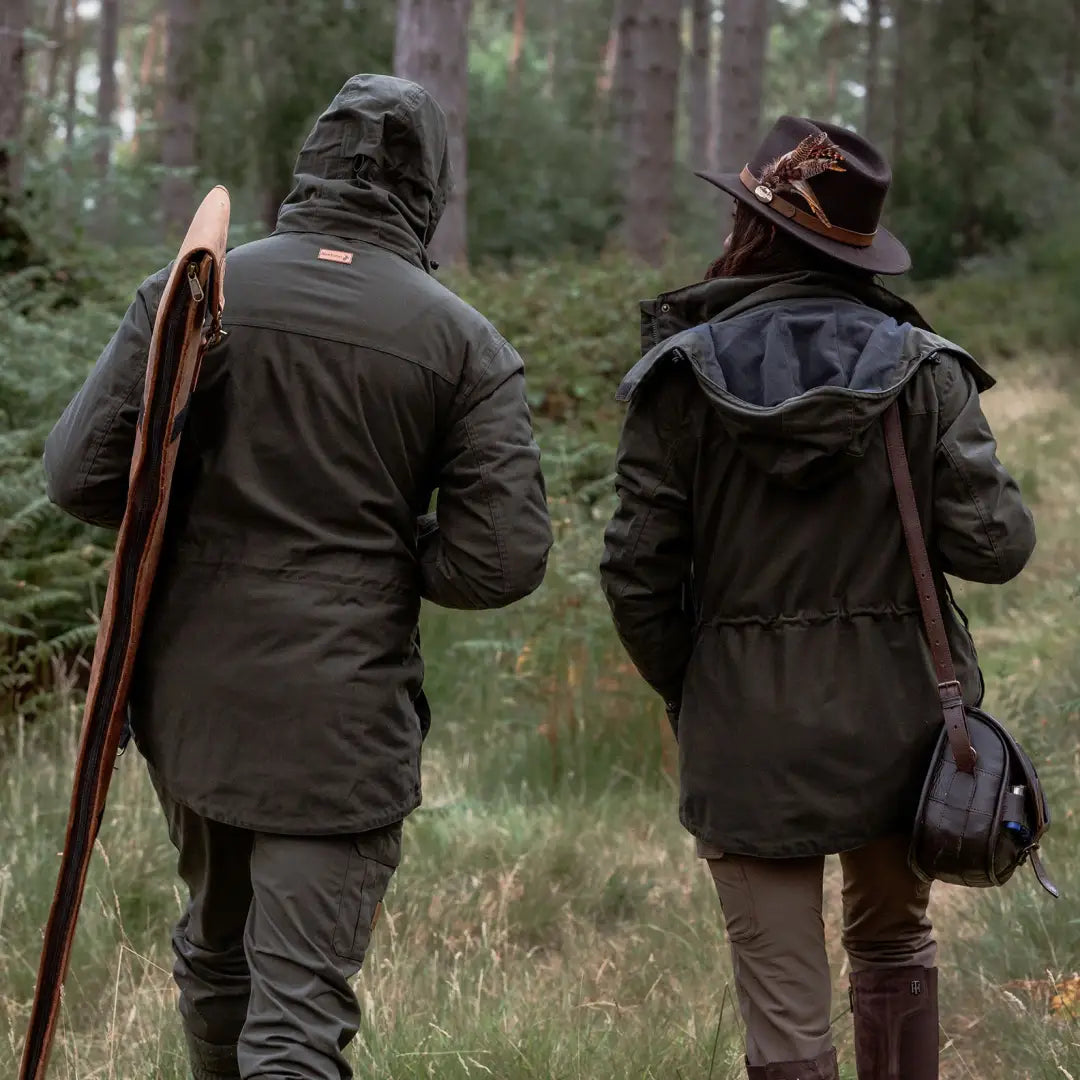 Two people in hunting attire wearing Forest Ladies Marsh Jacket for outdoor adventure