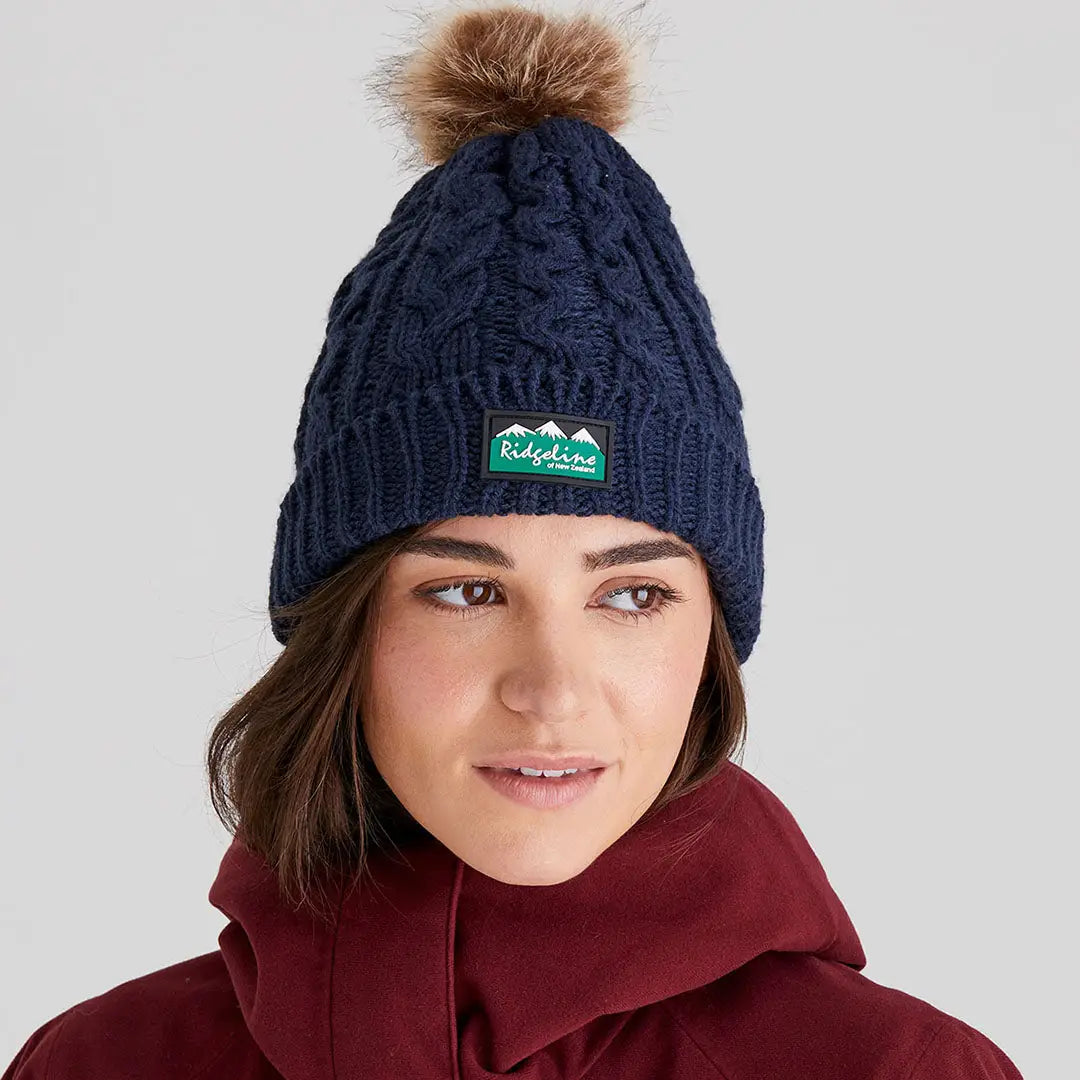 Dark blue Nordic Fleck Bobble Hat with brown faux fur pom-pom and Ridgeline patch