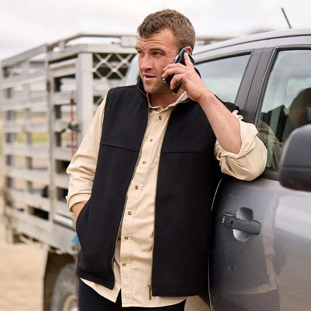 Man in Swanndri Saddleback Vest talking on phone, perfect for country clothing and hunting outdoors