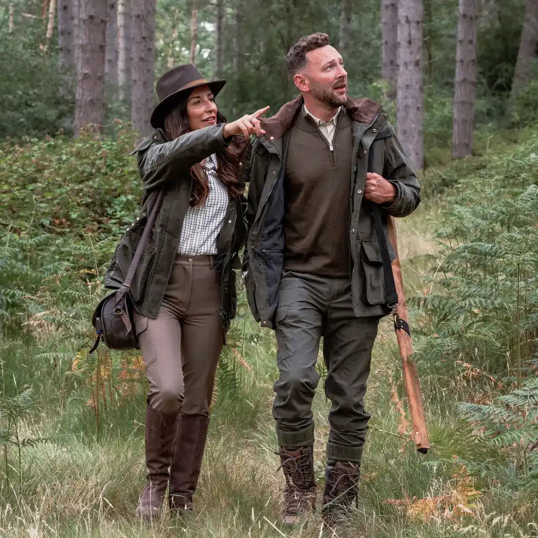 Hunting couple in outdoor attire wearing New Forest Marsh Jacket in forest marsh area