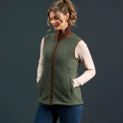 Woman wearing Alan Paine Aylsham Ladies Fleece Gilet in green with brown trim for warmer days