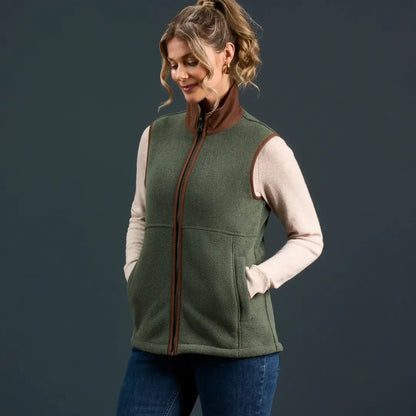 Woman wearing Alan Paine Aylsham Ladies Fleece Gilet in green with brown trim for warmer days