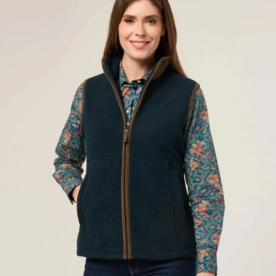 Woman’s teal vest with brown trim over patterned shirt, perfect for warmer days worn