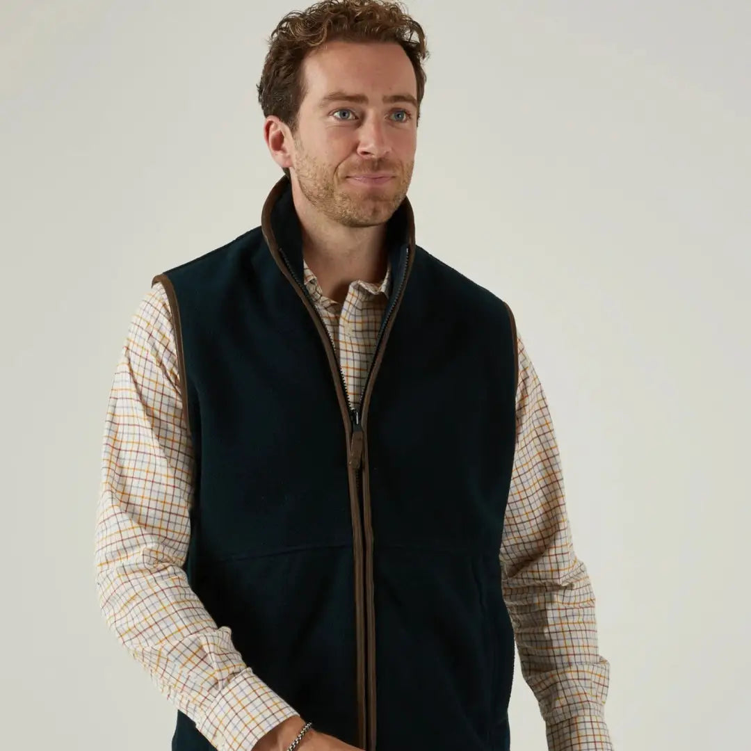 Men’s dark green fleece vest with brown trim over plaid shirt - Alan Paine Aylsham versatile piece