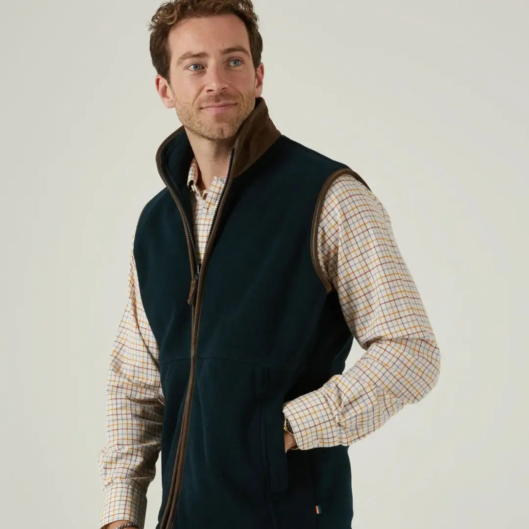 Alan Paine Aylsham men’s fleece gilet, a versatile piece with brown trim over a plaid shirt