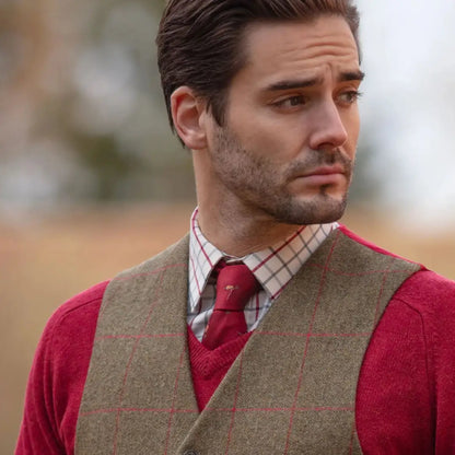 Man in red sweater plaid shirt and tweed vest from Alan Paine’s softest collection