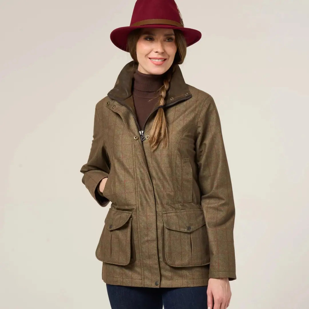A woman in a brown tweed Didsmere Ladies Coat and maroon hat staying warm