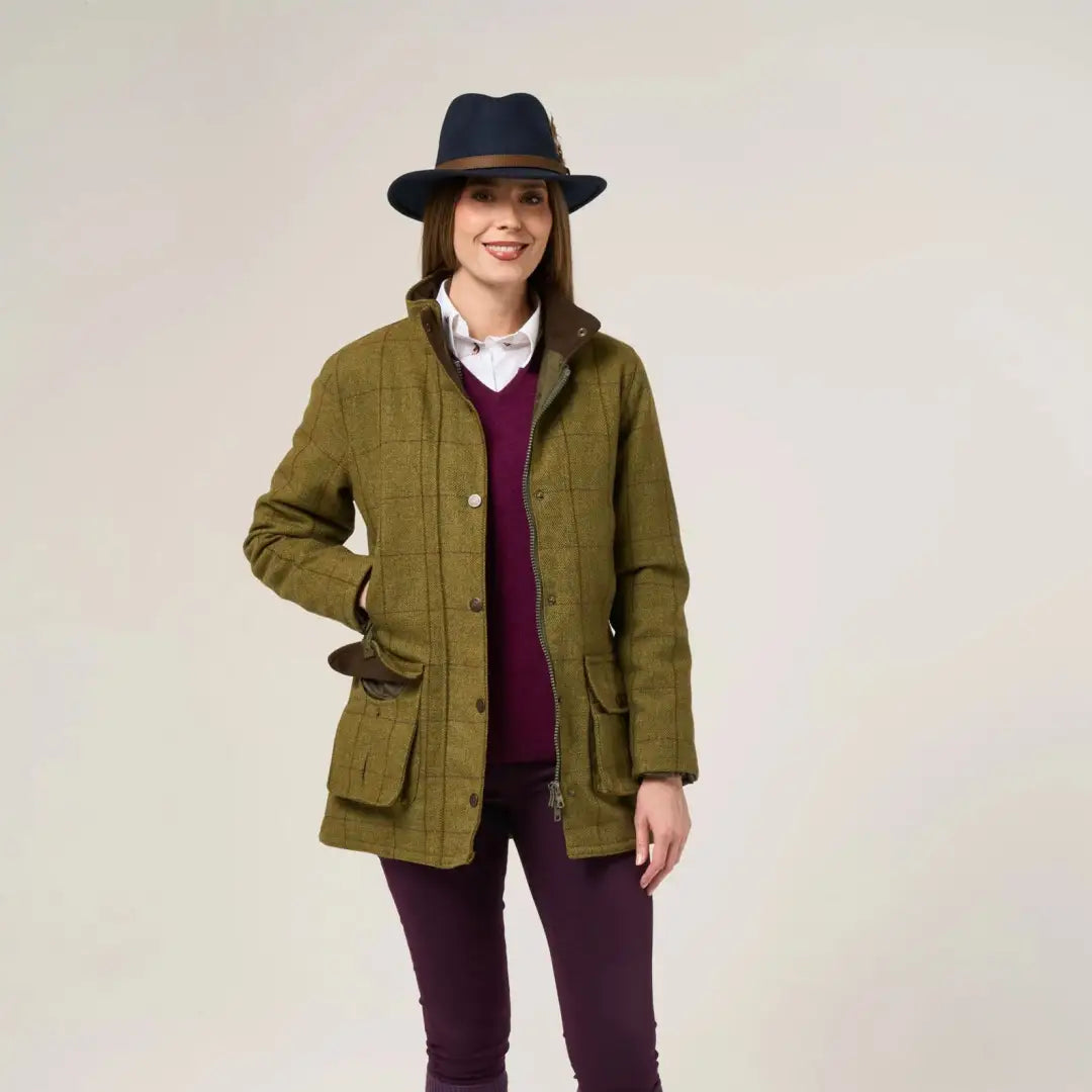 Woman wearing Alan Paine Rutland olive green tweed waterproof coat over red sweater