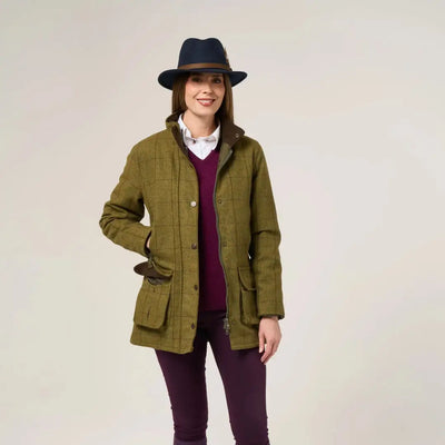 Woman wearing Alan Paine Rutland olive green tweed waterproof coat over red sweater