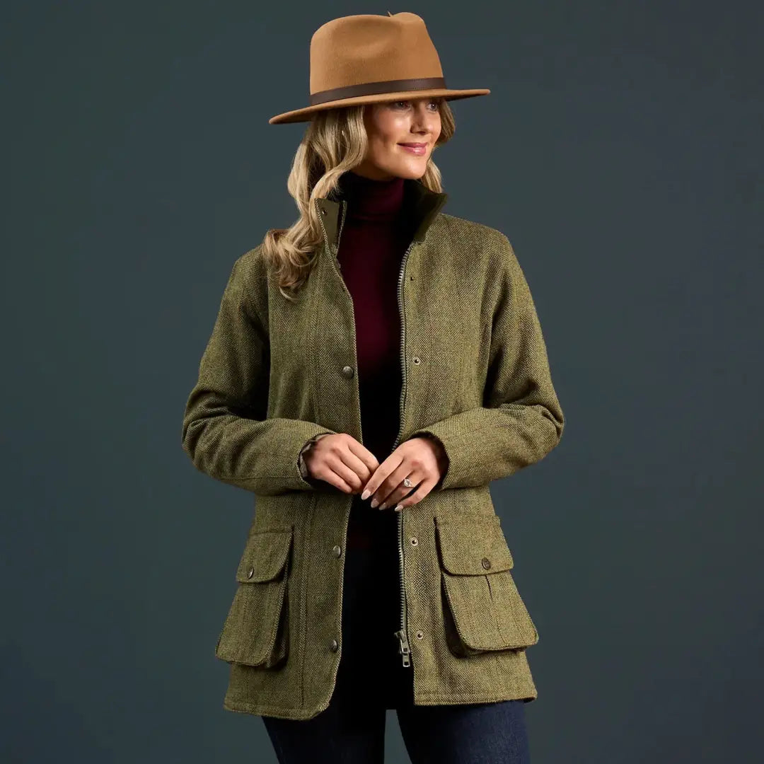 Woman in olive green tweed jacket and tan fedora hat wearing Alan Paine Rutland coat