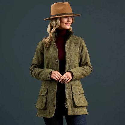 Woman in olive green tweed jacket and tan fedora hat wearing Alan Paine Rutland coat