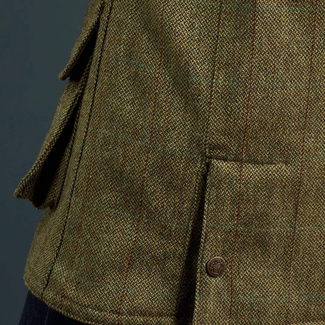Close-up of green tweed Alan Paine Rutland coat with pleats and button closure