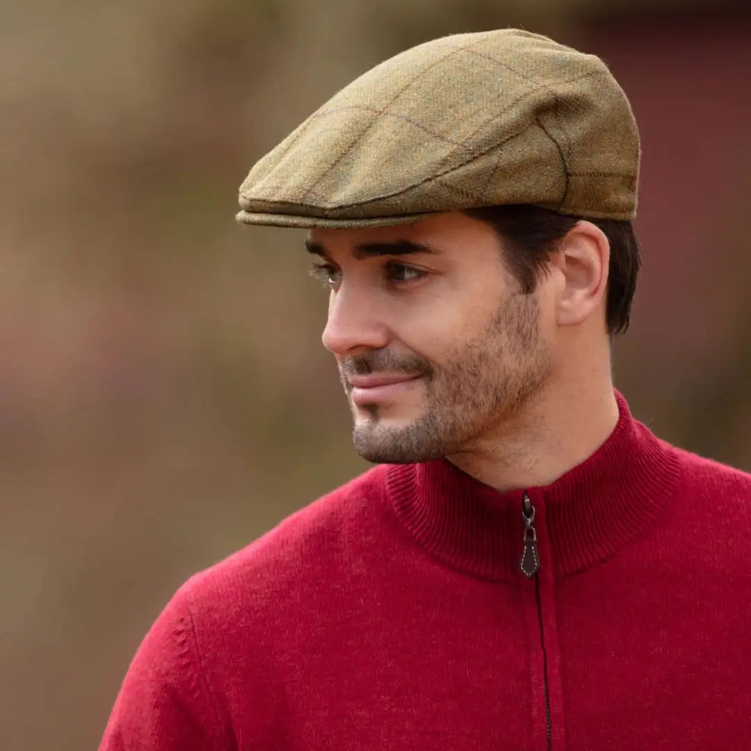 Man wearing green plaid flat cap and red sweater, Alan Paine Rutland flat cap