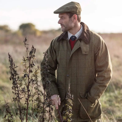 Man in a flat cap and jacket in a field, showcasing Alan Paine Rutland style