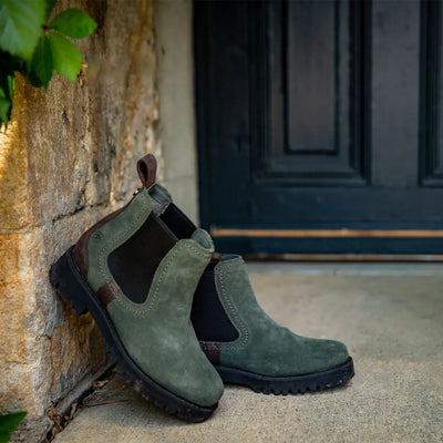 Green suede Chelsea boot featuring black elastic side and rugged sole for country clothing