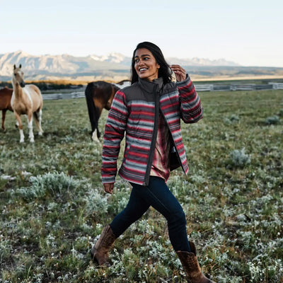 Woman in colorful striped jacket showcasing Ariat Womens Heritage R Toe Western Boots in the outdoors
