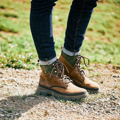 Brown leather lace-up boots with rolled-up jeans, perfect for country clothing and outdoors
