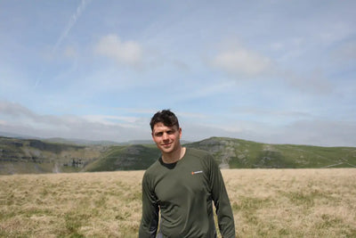 Man in green long-sleeve Bushbuck Apex Crew Base Layer for outdoor activities