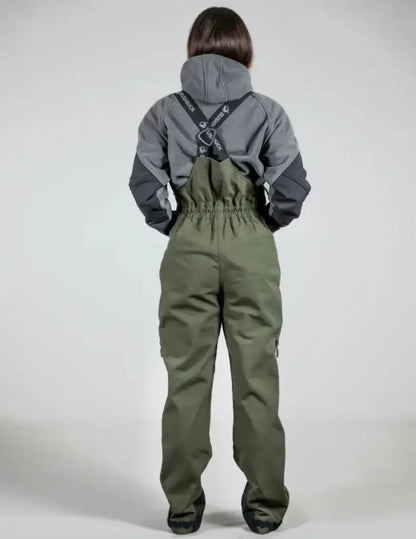 Person wearing bushbuck defender waterproof bib overtrousers with olive green bib and gray defender jacket