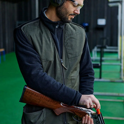 Man loading shotgun while wearing the Atlas Shooting Waistcoat for ultimate comfort