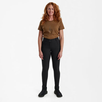 Standing woman in brown t-shirt and black pants wearing Deerhunter Lady Hunting Tights