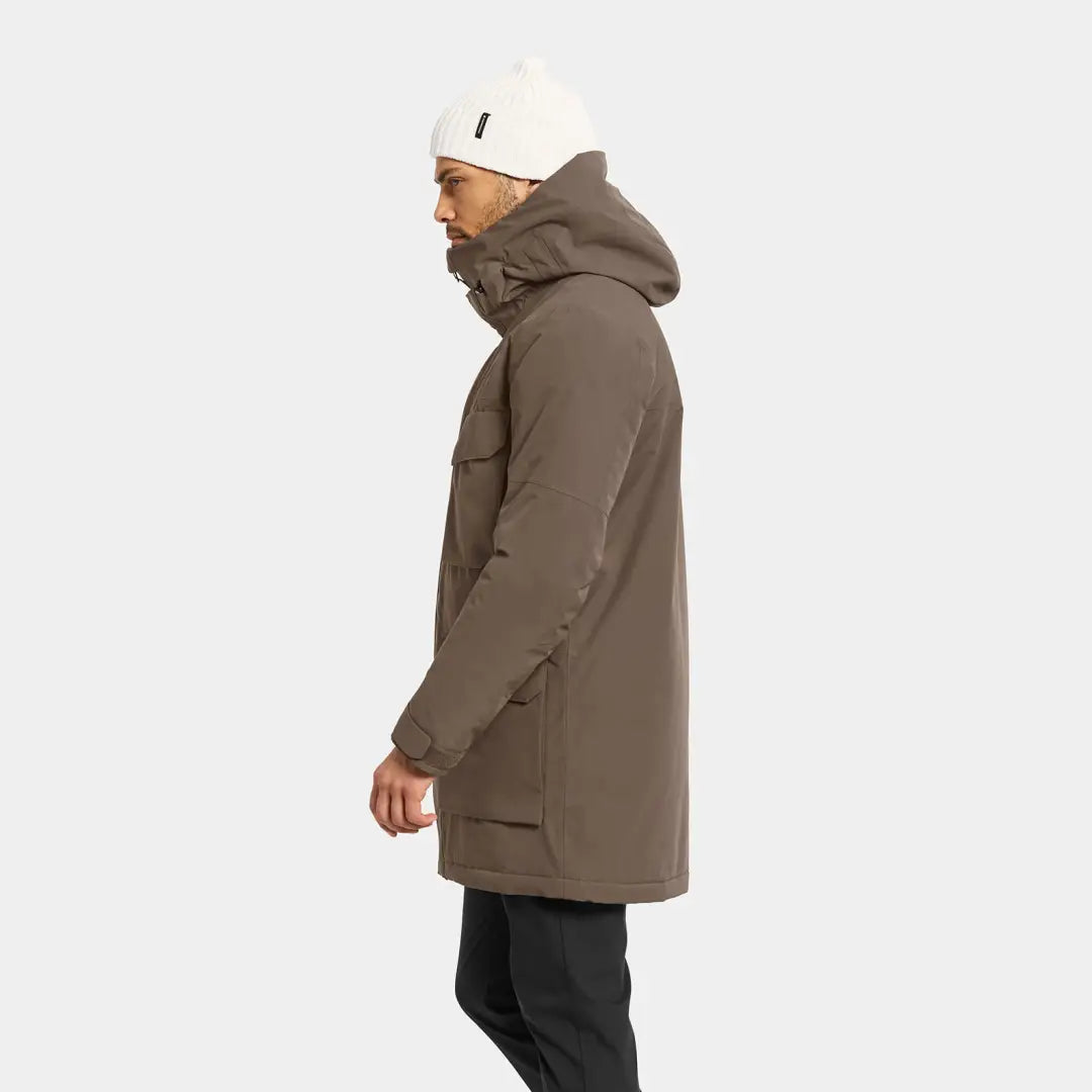 Men’s brown Drew Parka with black pants and white beanie perfect for chilly days in country clothing