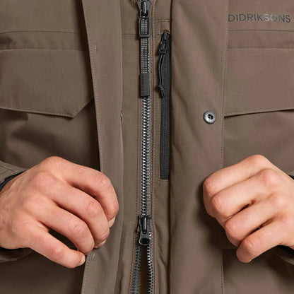 Person zipping up Didriksons Drew Parka in country clothing style for chilly days