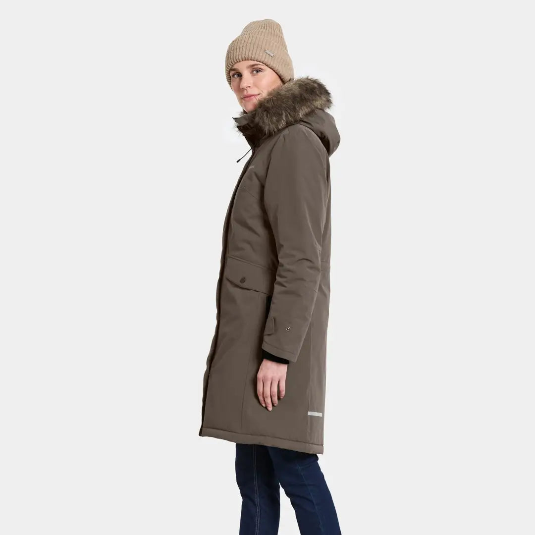 Woman wearing long olive green classic Didriksons parka with fur-lined hood