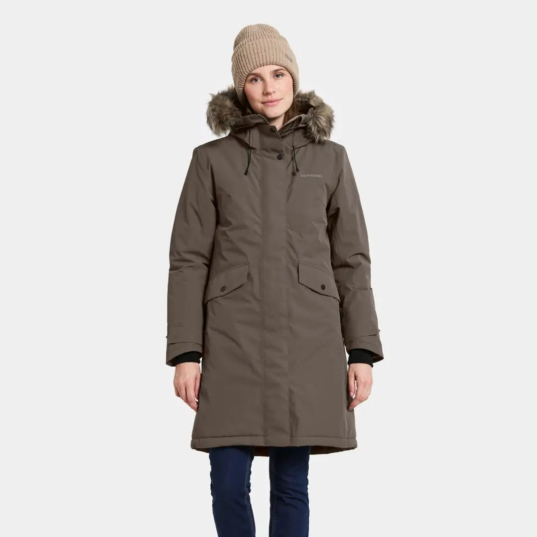 Woman wearing a long olive-green Didriksons Erika Womens Parka with fur-lined hood