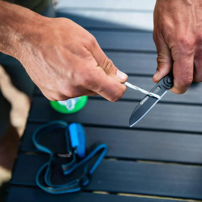 Hands opening a Gerber Armbar Scout with a stainless steel frame for outdoor adventures