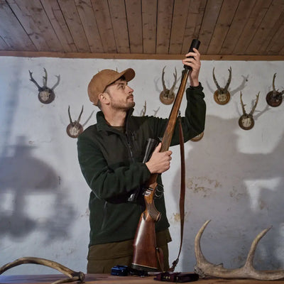Hunter loading rifle in front of Härkila Fjell Fleece Jacket, our cozy fleece jacket
