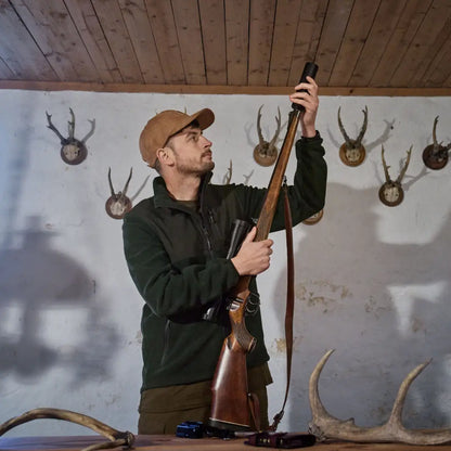 Hunter loading rifle in front of Härkila Fjell Fleece Jacket, our cozy fleece jacket