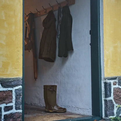 Muddy brown rubber boot with Härkila Fjell Fleece Jacket for outdoor adventure