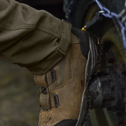 Muddy brown leather boot paired with Härkila Hill Trousers for hunting and country wear