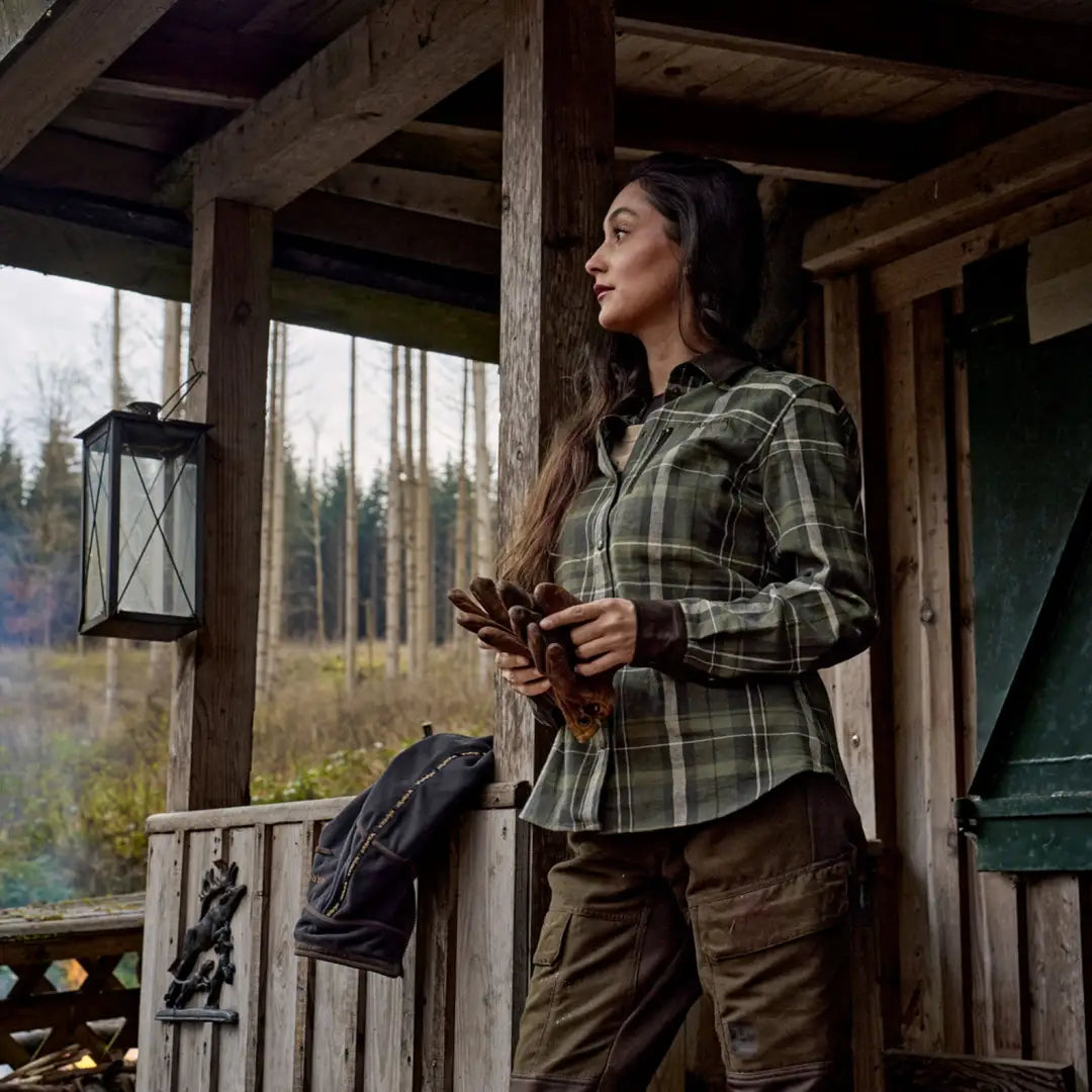 Woman in plaid shirt and cargo pants in outdoor country clothing for hunting or adventures