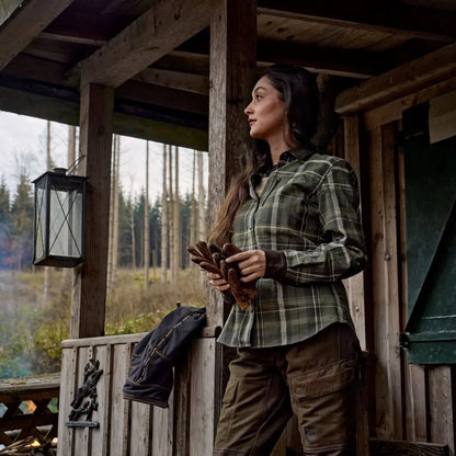 Woman in plaid shirt and cargo pants in outdoor country clothing for hunting or adventures