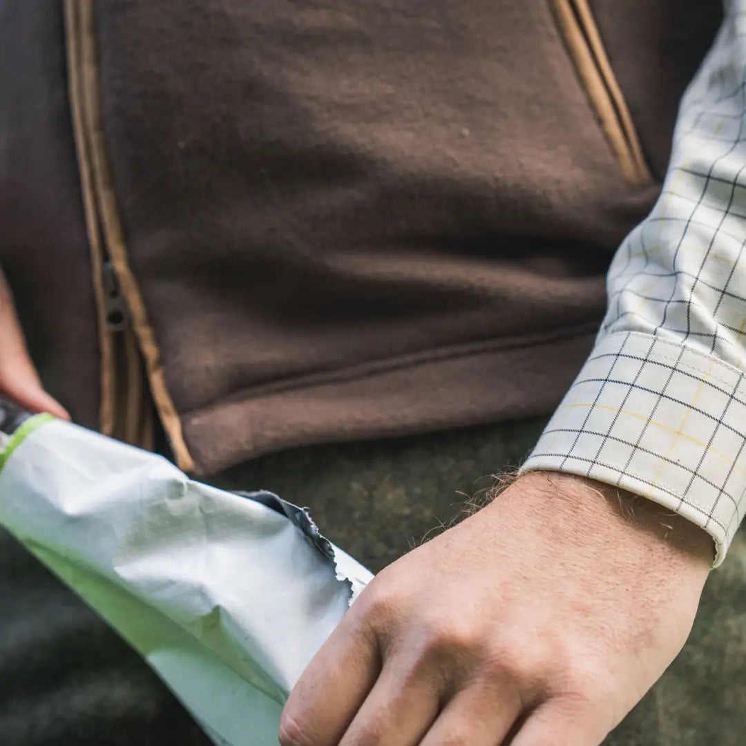 Man opening a package showing Härkila Portfield Long Sleeve Shirt, perfect long sleeve shirt for outdoor wear