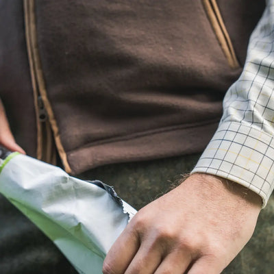 Man opening a package showing Härkila Portfield Long Sleeve Shirt, perfect long sleeve shirt for outdoor wear
