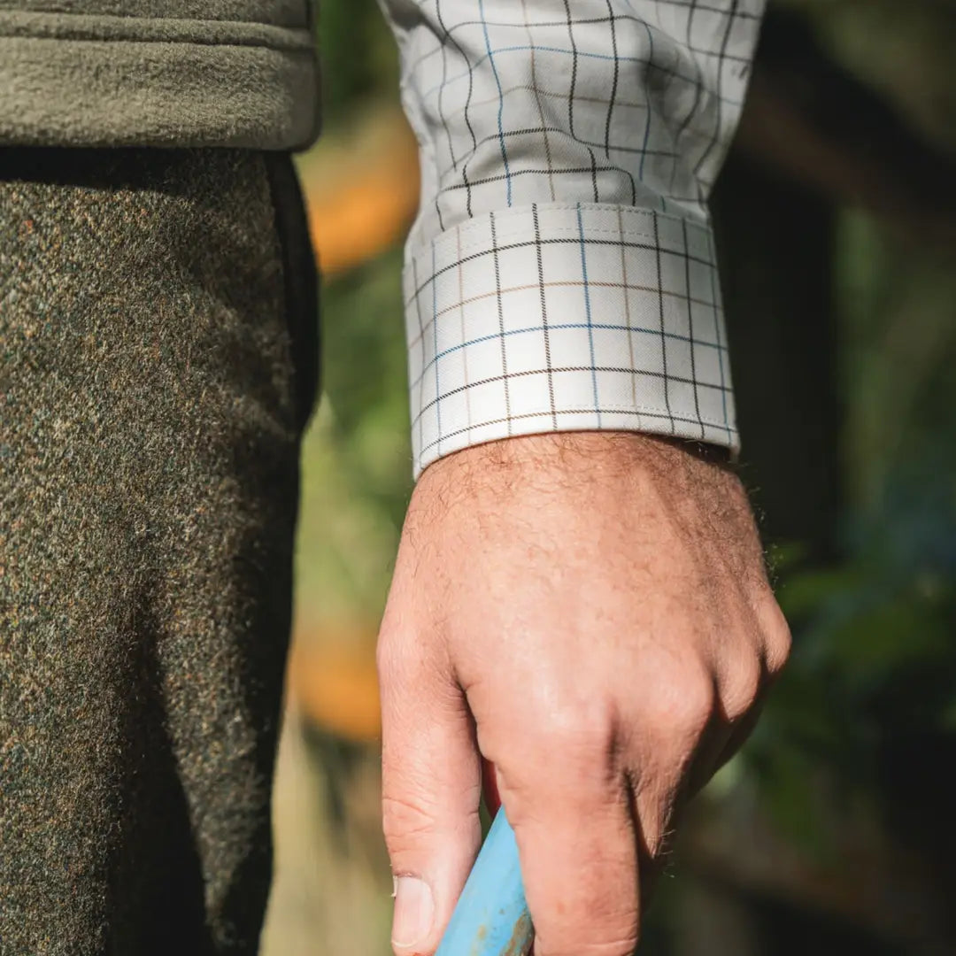 Man’s hand holding blue object wearing Härkila Portfield Long Sleeve Shirt