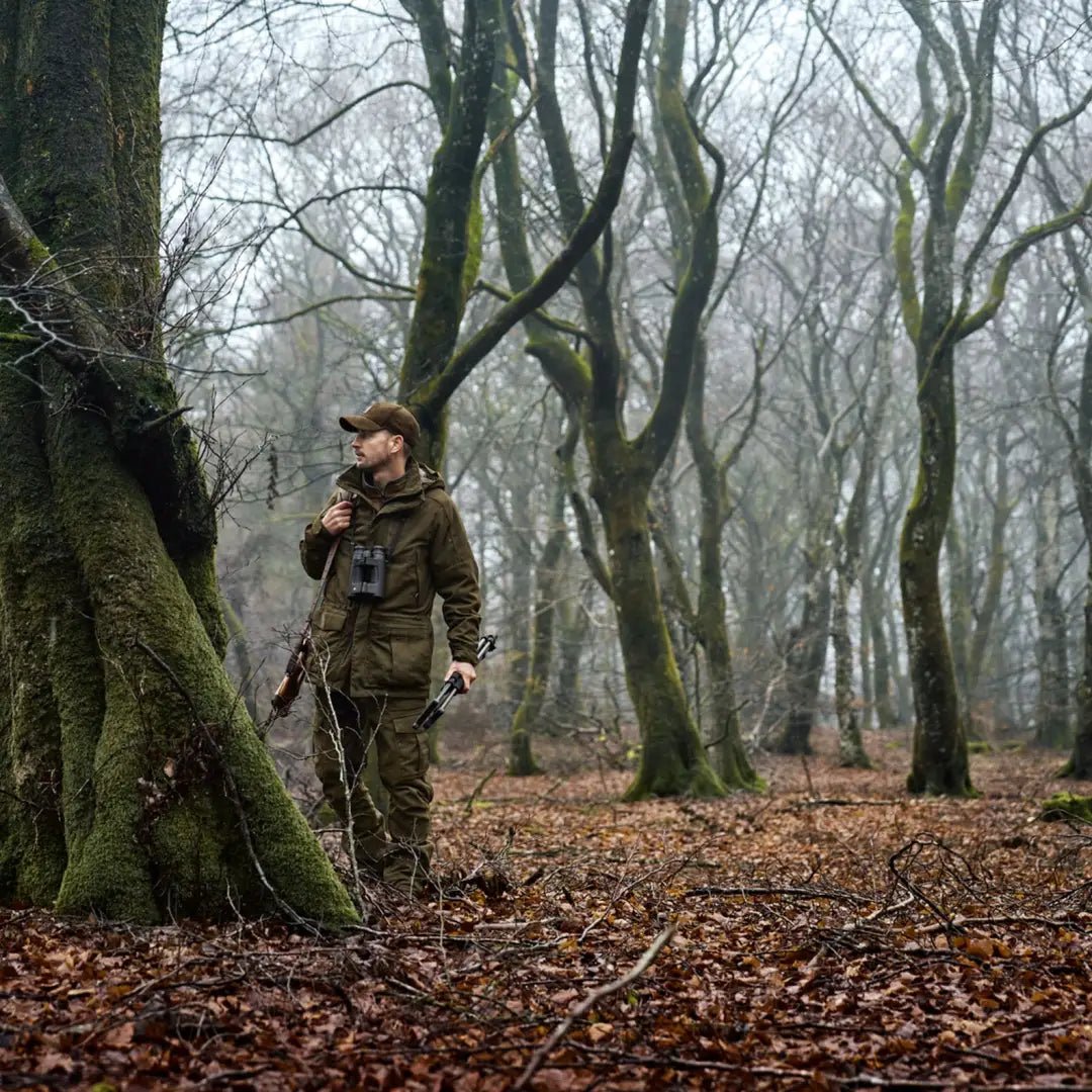 Hunter in camouflage gear wearing Härkila Pro Hunter GTX Legacy Jacket for ultimate stealth