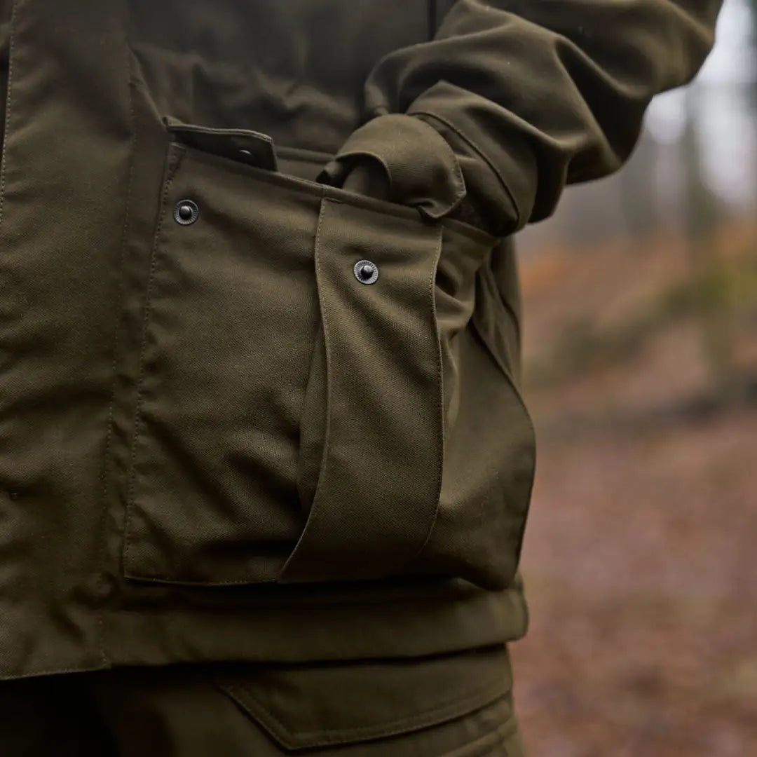 Olive green Härkila Pro Hunter GTX Legacy Jacket with hand in pocket for outdoor use